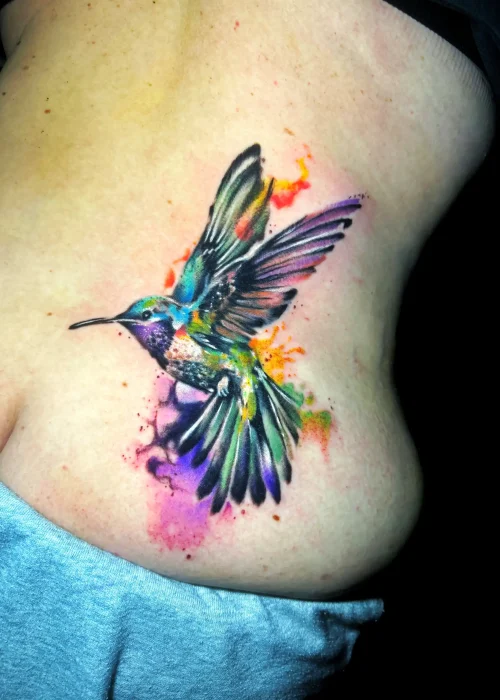 tatuaje acuarela de un pájaro en la espalda