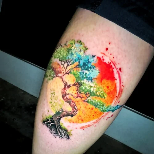 un bonsái en tatuaje acuarela en el muslo