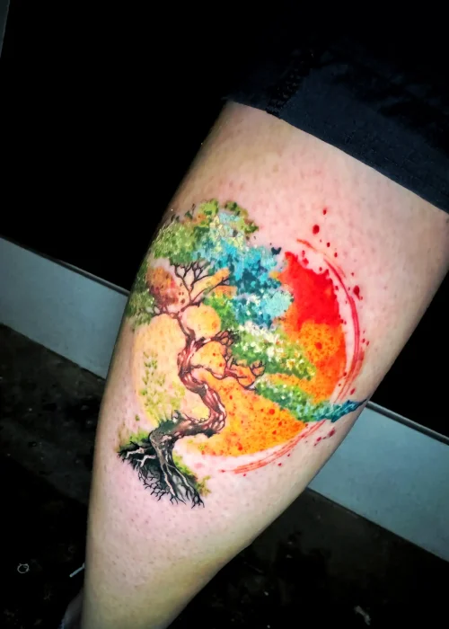un bonsái en tatuaje acuarela en el muslo